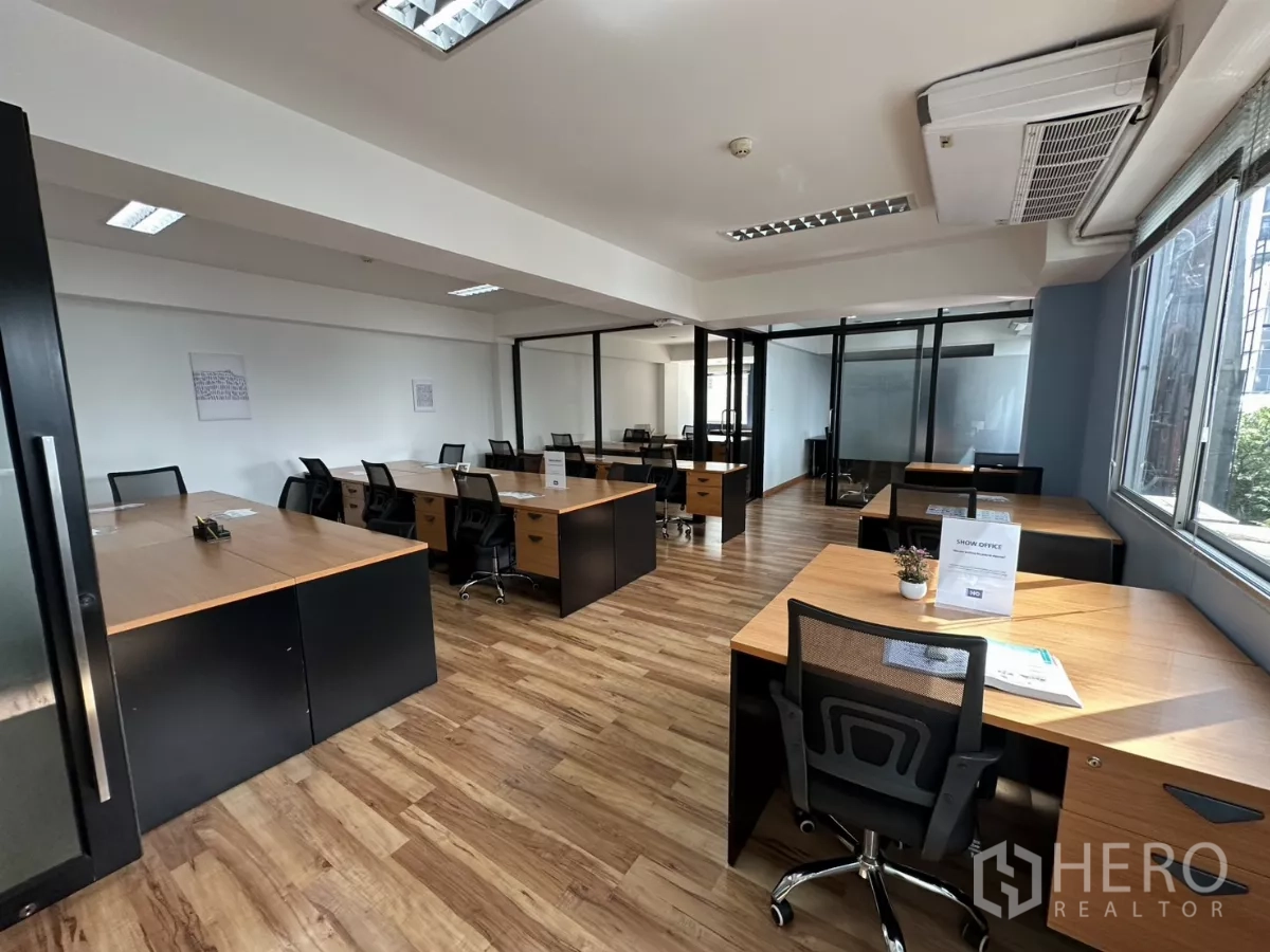 办公空间 出租在Watthana, Bangkok - 采光充足的开放式办公室，木纹地板，成排工位与玻璃会议室。