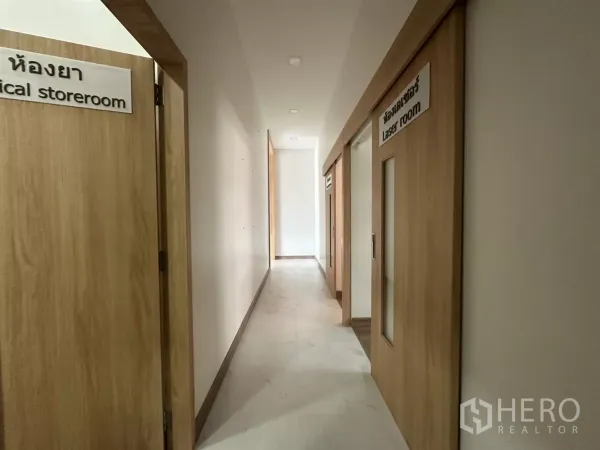 零售空间 出租在Phra Khanong, Bangkok - 宽敞走廊，木质滑门通向治疗室和储物间。