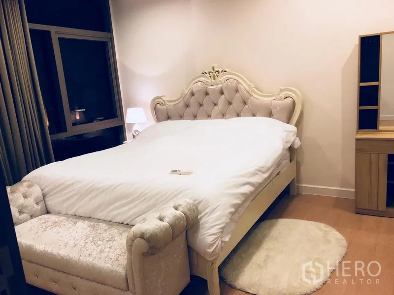 公寓 出租或出售在Bang Rak, Bangkok - 优雅卧室，菱格软包床头、同款长凳与大窗帘窗。