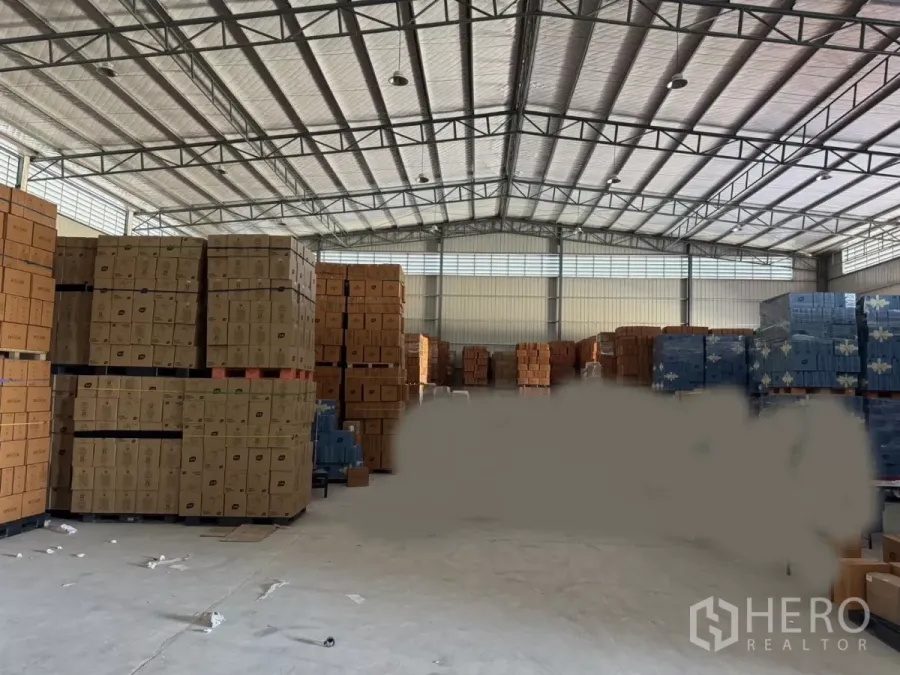 货栈 出租在Bang Bo, Samut Prakan - 仓库内部，高挑隔热钢结构屋顶，堆放托盘，混凝土地面，适合大宗存储。