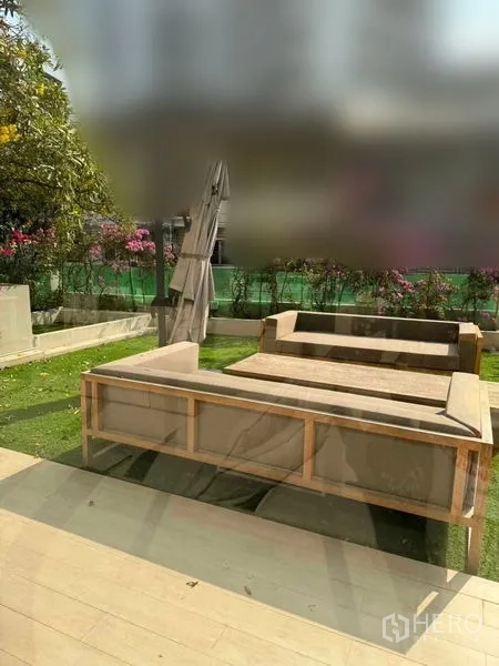 ทาวน์เฮาส์ ให้เช่าในWatthana, Bangkok - สวนชั้นล่างพร้อมชุดโซฟากลางแจ้งและสนามหญ้า.