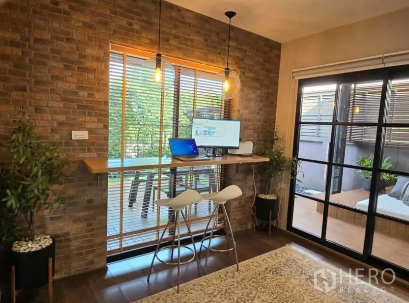 独立式住宅 出租在Bang Phli, Samut Prakan - 砖墙工作角，吧台书桌与吊灯，可望露台