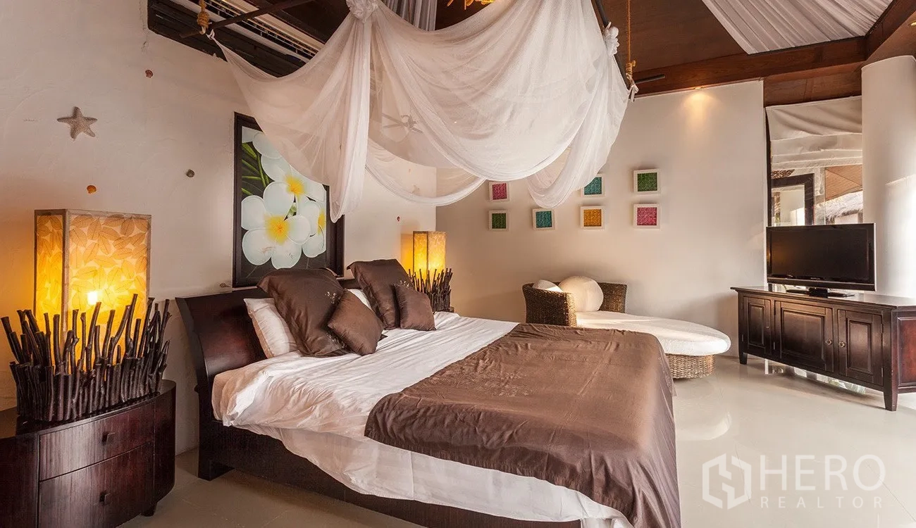 Detached House for sale in Hua Hin, Prachuap Khiri Khan - Master bedroom with canopy netting, warm lighting and dark wood furniture.
