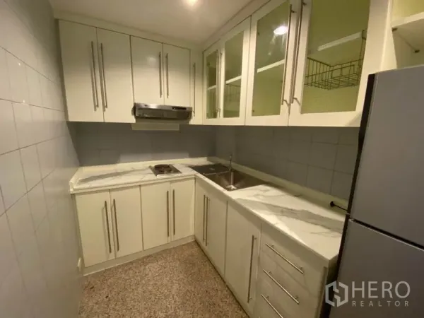 คอนโด ให้เช่าในWatthana, Bangkok - ครัวรูปตัวแอล เคาน์เตอร์ลายหินอ่อน อ่างล้างจาน และเตาพร้อมฮู้ดดูดควัน