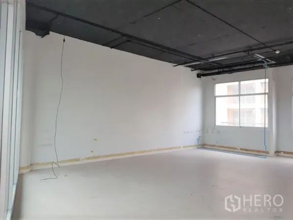 办公空间 出租在Phra Khanong, Bangkok - 未配家具的开放式办公室，黑色外露天花、白墙与大窗户，采光充足。