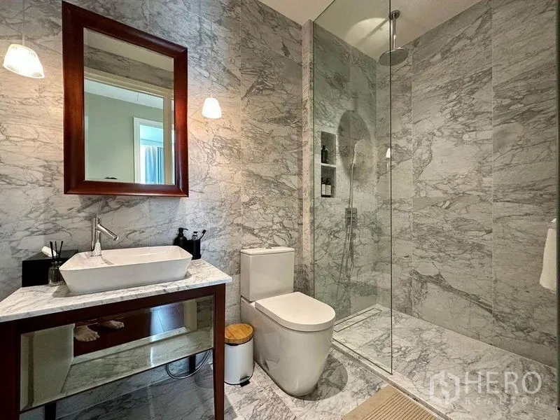 公寓 出租在Watthana, Bangkok - 次卫大理石装修，悬空洗手台、马桶与玻璃淋浴间。