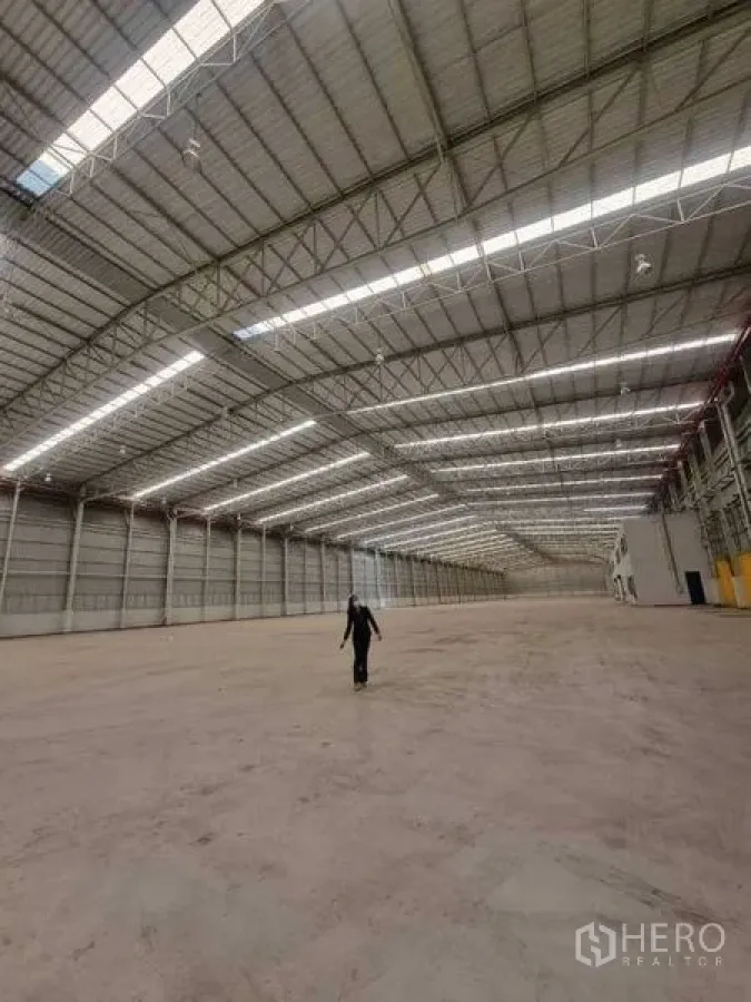 Factory for rent in Bang Pakong, Chachoengsao - Long‑span warehouse interior with natural daylight strips, ventilated ridge and smooth concrete floor.