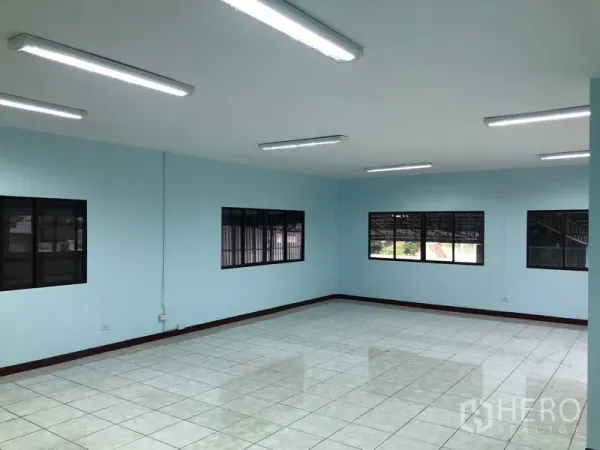 Warehouse for rent in Sai Noi, Nonthaburi - Bright tiled office room with fluorescent lighting and large windows.