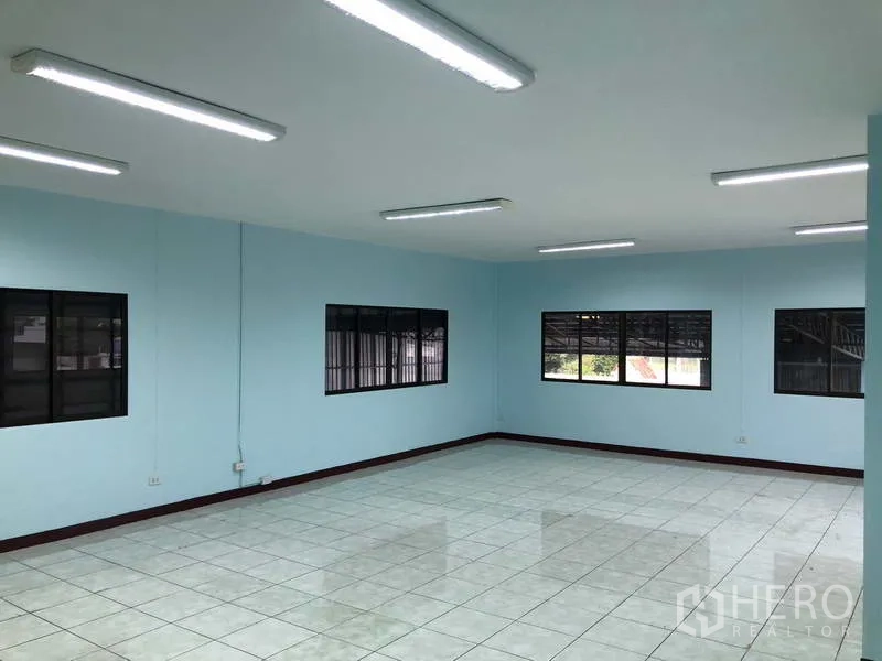 Warehouse for rent in Sai Noi, Nonthaburi - Bright tiled office room with fluorescent lighting and large windows.