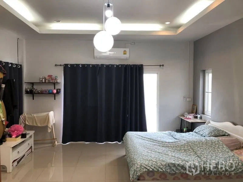 บ้าน ขายในLam Luk Ka, Pathum Thani - ห้องนอนใหญ่พร้อมเตียง โคมไฟแขวน และม่านทึบ