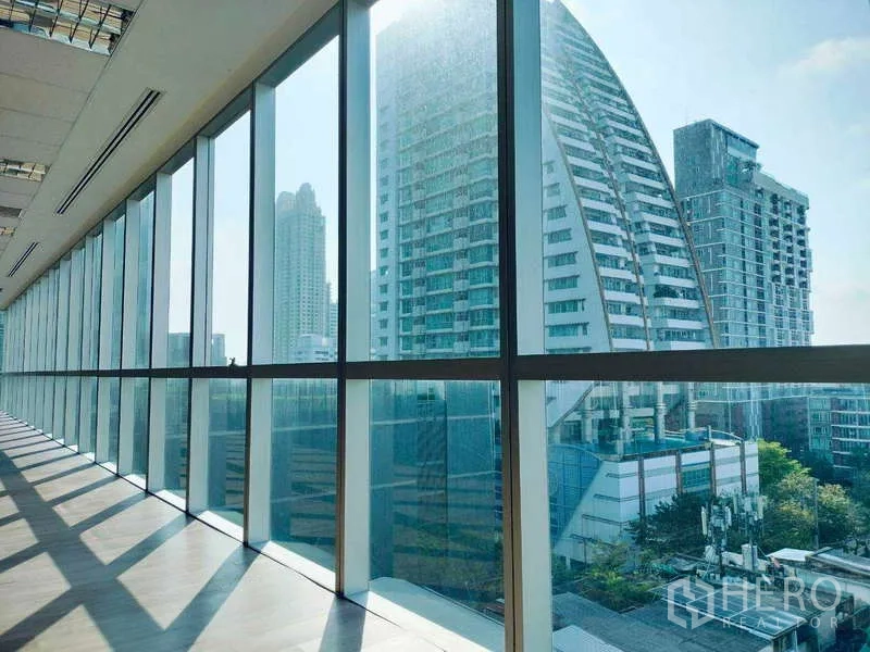 Office Space for rent in Sathon, Bangkok - Modern high‑rise skyline viewed through the office’s full‑height curtain wall windows.