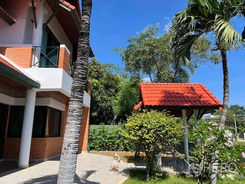 Detached House for rent in Bang Phli, Samut Prakan - Corner exterior with palm trees, landscaped garden and red-roof pavilion beside the house.