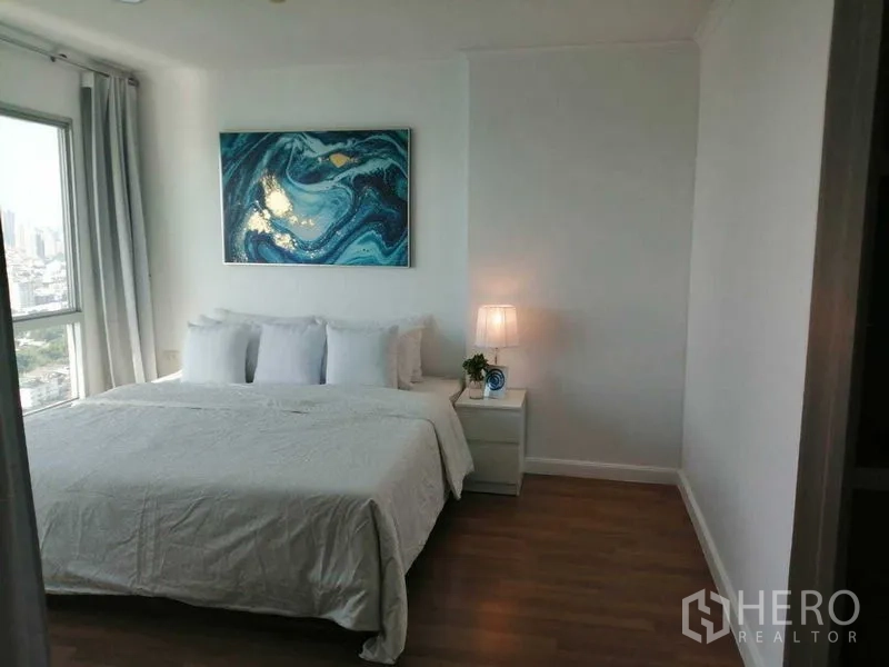 公寓 出售在Yan Nawa, Bangkok - 主卧配大床、床头灯、装饰画与城市景观窗。