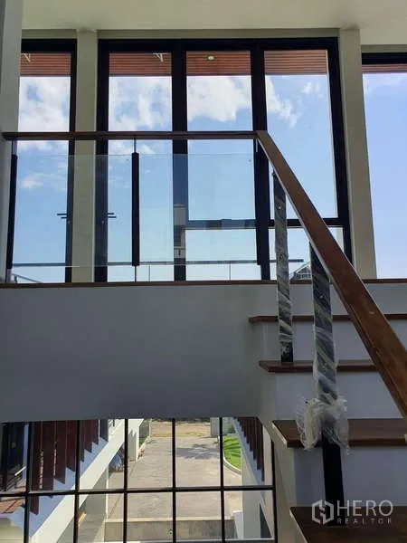独立式住宅 出租在Phra Khanong, Bangkok - 采光充足的楼梯间，落地窗与玻璃扶手。