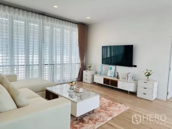 บ้าน ให้เช่าหรือขายในBang Kapi, Bangkok - มุมห้องนั่งเล่น โต๊ะกลางหินอ่อน ตู้ทีวี และผนังกระจกสูง