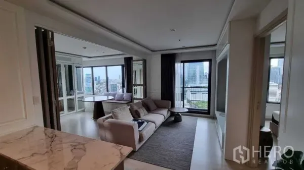 Condominium for sale in Pathum Wan, Bangkok - Bright living room with sofa, balcony doors and Bangkok skyline view