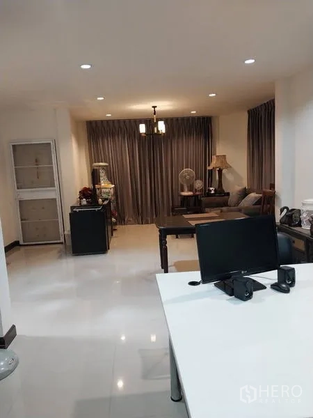 Detached House for rent in Khlong Sam Wa, Bangkok - Open-plan living area with study desk, glossy floors, and ceiling lights.