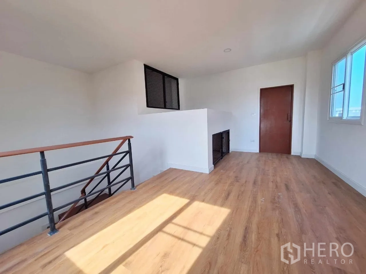 Home Office for sale in Bueng Kum, Bangkok - Top-floor landing room with window, wood floors and access door.