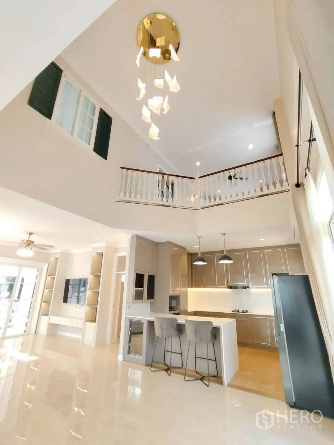 Detached House for rent in Bang Na, Bangkok - Double-height living space with chandelier overlooking the kitchen.