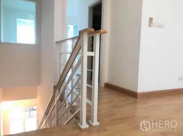 ทาวน์เฮาส์ ให้เช่าในWang Thonglang, Bangkok - โถงชั้นบนปูพื้นไม้ ราวบันไดสีขาว มีประตูห้องนอนและแสงธรรมชาติส่องถึง