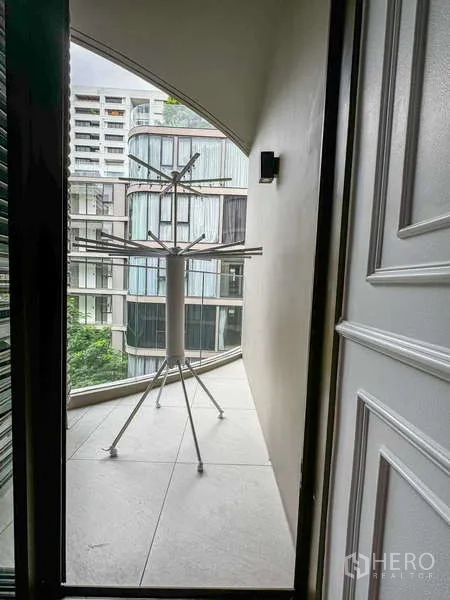 คอนโด ให้เช่า - ระเบียงแคบพร้อมราวตากผ้า มองเห็นอาคารสไตล์ร่วมสมัย