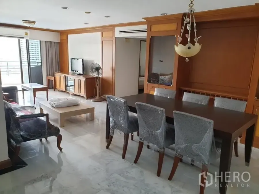 Condominium for rent in Watthana, Bangkok - Bright living and dining room with marble floors, wood built-ins and sliding doors to a balcony in a Bangkok condo.
