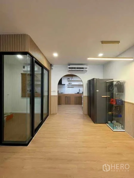 Townhouse for rent or sale in Bang Kapi, Bangkok - Open-plan area facing the kitchen arch with refrigerator and glass display cabinet.