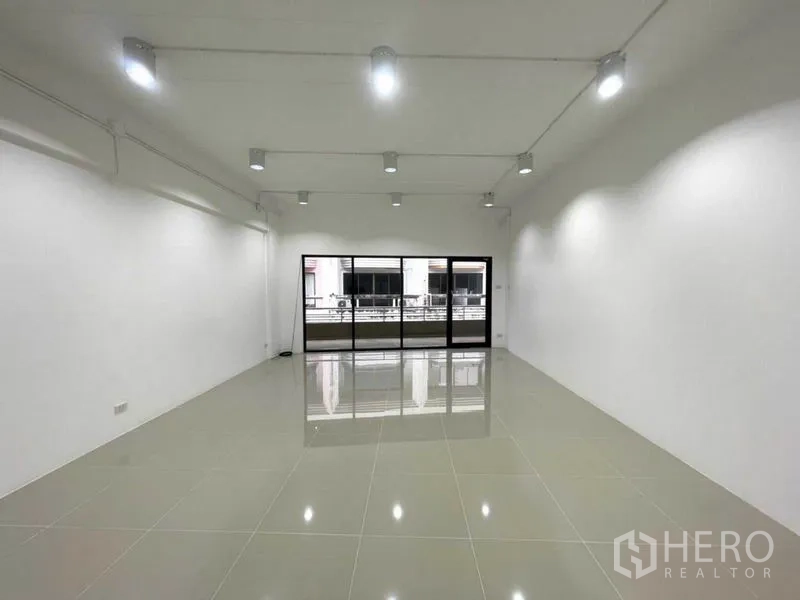 办公空间 出租在Khlong Toei, Bangkok - 开间办公室面向黑框落地推拉玻璃门与外走道。