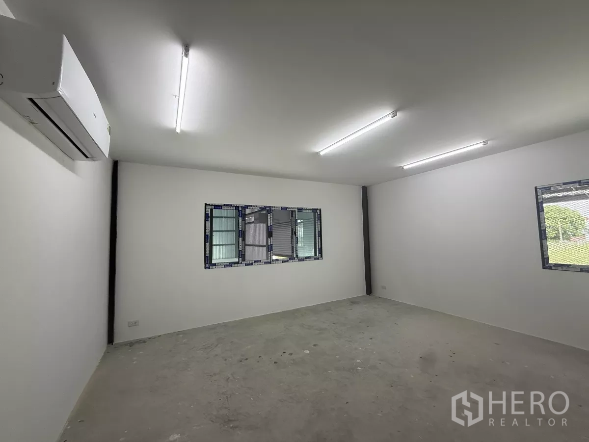 Warehouse for rent in Lat Krabang, Bangkok - Bright air‑conditioned office with fluorescent lighting and windows overlooking the warehouse.