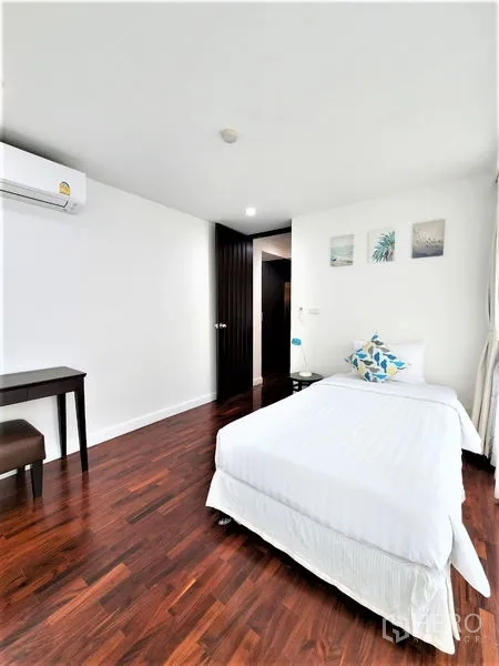 公寓 出租在Bang Rak, Bangkok - 次卧采光佳，单人床、书桌、墙饰、空调与木地板。