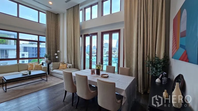 คอนโด ให้เช่าในPathum Wan, Bangkok - พื้นที่นั่งเล่นและรับประทานอาหารเพดานสูงพร้อมหน้าต่างเต็มบานและวิวเมือง