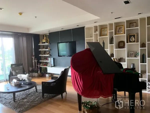 คอนโด ขายในKhlong Toei, Bangkok - ห้องนั่งเล่นมีชั้นบิลท์อิน ผนังทีวี และเปียโนใหญ่ใกล้ประตูระเบียง