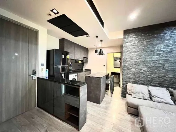 Condominium for rent - Open-plan kitchen with dark cabinetry, stone island and pendant lights, adjoining the living area.