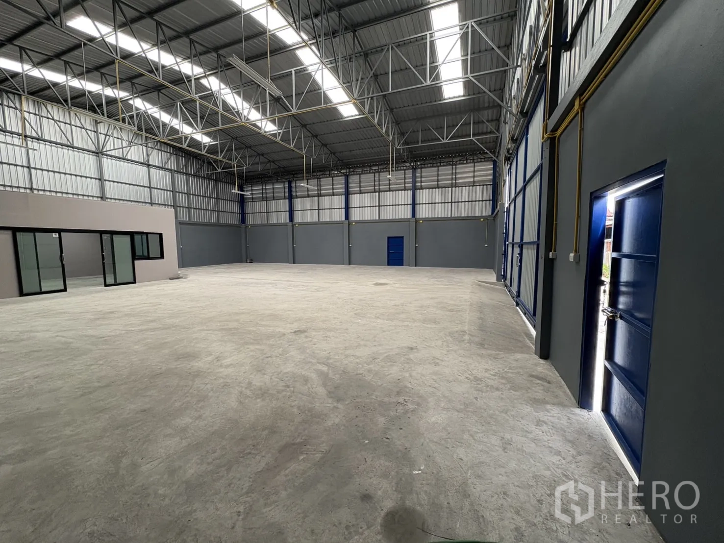 คลังสินค้า ให้เช่าในBang Phli, Samut Prakan - พื้นที่เก็บของโล่ง เห็นประตูออฟฟิศกระจก ประตูบริการด้านข้าง และไฟแขวนเพดานสูง