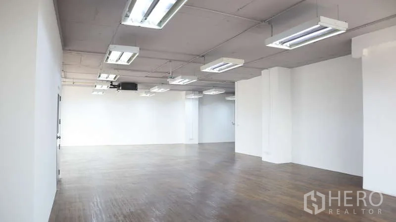 สำนักงาน ให้เช่า - โถงทำงานยาวโปร่ง ติดไฟฟลูออเรสเซนต์ เสาและพื้นไม้โทนอบอุ่น