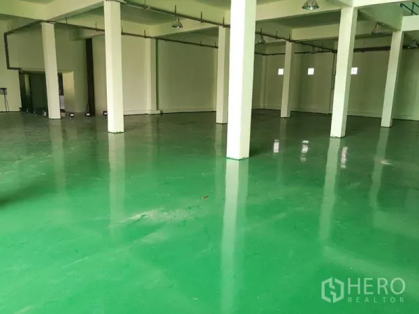 Factory for rent in Mueang Samut Sakhon, Samut Sakhon - Spacious factory hall with glossy green epoxy floor, white columns, and high ceiling lights.