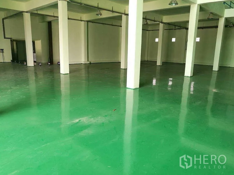 Factory for rent in Mueang Samut Sakhon, Samut Sakhon - Spacious factory hall with glossy green epoxy floor, white columns, and high ceiling lights.