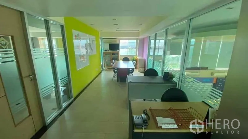 Office Space for sale in Bang Kapi, Bangkok - Corridor with glass-partitioned offices, workstations and a small meeting table.