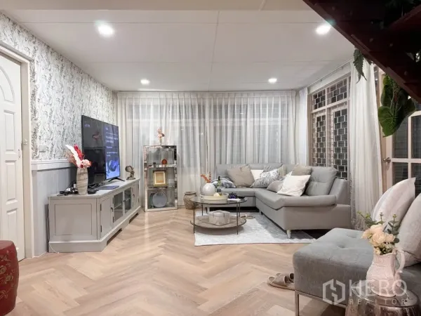 บ้าน ให้เช่าในHuai Khwang, Bangkok - ห้องนั่งเล่นสว่างด้วยโซฟาเข้ามุม ตู้ทีวี และพื้นลายก้างปลา.