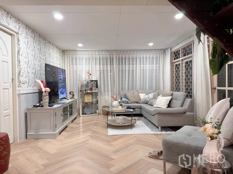 บ้าน ให้เช่าในHuai Khwang, Bangkok - ห้องนั่งเล่นสว่างด้วยโซฟาเข้ามุม ตู้ทีวี และพื้นลายก้างปลา.