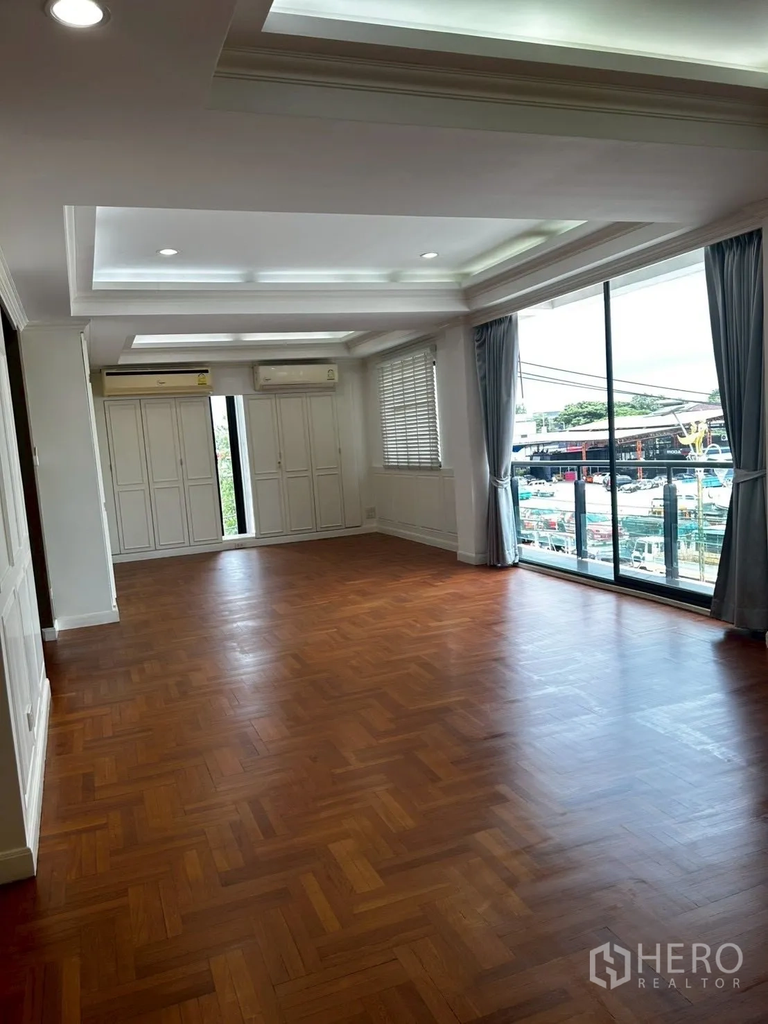 โชว์รูม for rent or sale in Bang Phli, Samut Prakan - ห้องโล่งหน้าต่างบานใหญ่ พื้นไม้ปาร์เกต์ และตู้สีขาวบิวท์อิน