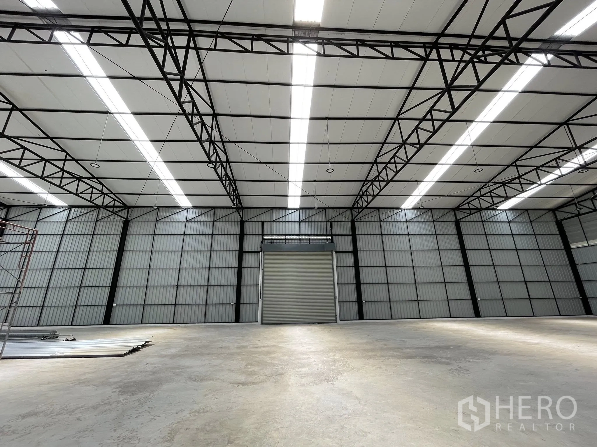 โกดัง for rent in Pak Kret, Nonthaburi - พื้นที่โล่งภายในหันสู่ประตูม้วนและโครงหลังคาพร้อมช่องรับแสง