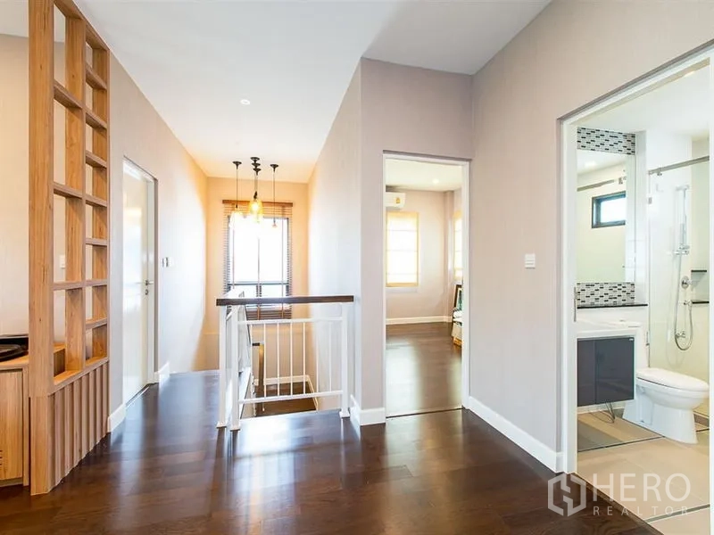 独立式住宅 出租或出售在Prawet, Bangkok - 二楼走廊，楼梯、吊灯与旁边的卫浴