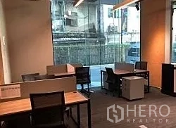 Office Space for rent in Khlong Toei, Bangkok - Bright workspace with multiple desks and a large street-facing glass window near BTS Phra Khanong.