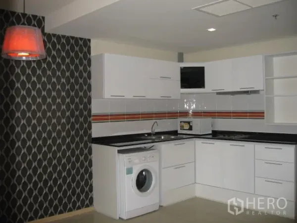 公寓 出租在Khlong Toei, Bangkok - 现代U型厨房，白色橱柜与防溅墙面，配洗衣机与吊灯。