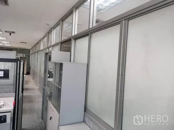 办公空间 出租在Bang Na, Bangkok - 办公室走廊，两侧为磨砂玻璃隔断与储物柜。