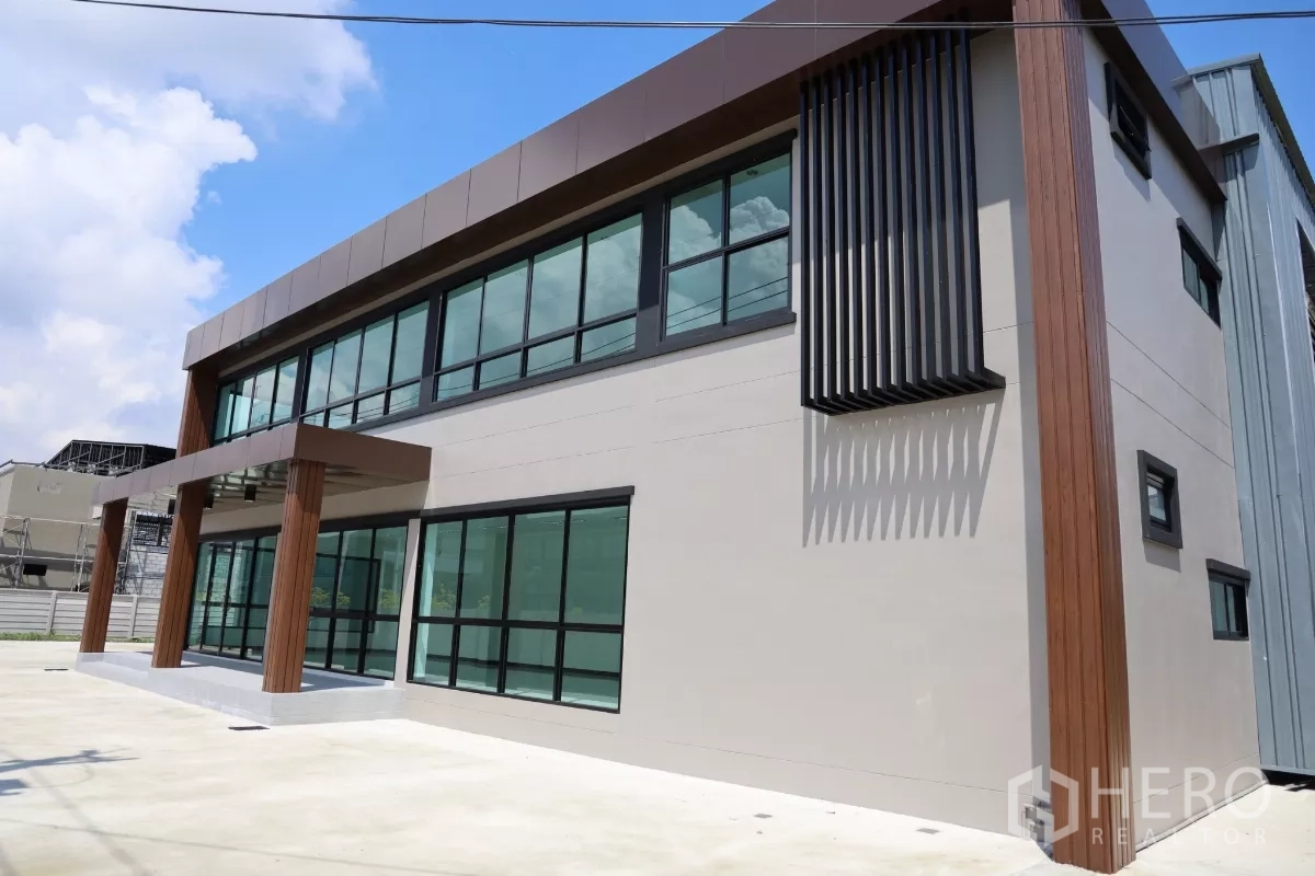 Factory for rent or sale in Bang Len, Nakhon Pathom - Side facade highlighting vertical sunshade fins and wide glazing on the contemporary office building.