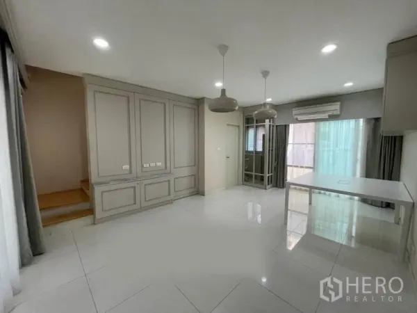 ทาวน์เฮาส์ ขายในSuan Luang, Bangkok - ห้องนั่งเล่นโปร่งสว่าง พร้อมตู้บิวท์อิน โคมแขวน และประตูกระจก ในทาวน์เฮาส์ย่านสวนหลวง