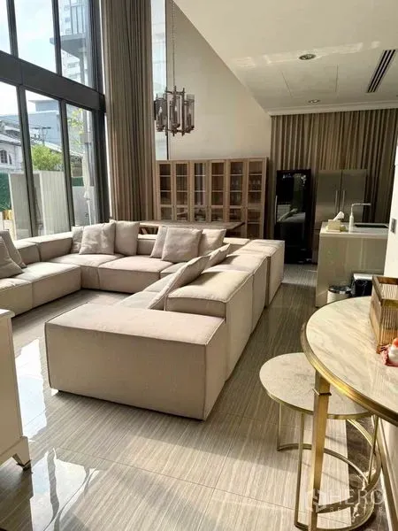 ทาวน์เฮาส์ ให้เช่าในWatthana, Bangkok - ห้องนั่งเล่นเพดานสูงผนังกระจกเต็มบาน โซฟาตัวแอลขนาดใหญ่ พร้อมครัวเปิด.