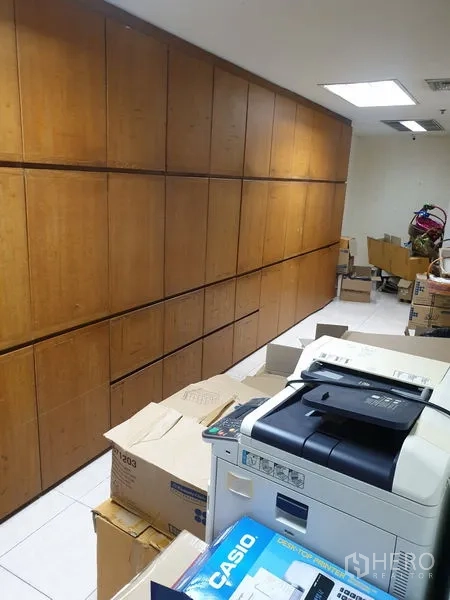 Office Space for rent - Back-office storage room with full-height wooden cabinets and a printer.